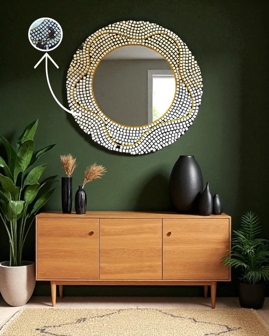 Round mirror mosaic decorative mirror with a gold accent on a green wall above a wooden cabinet.