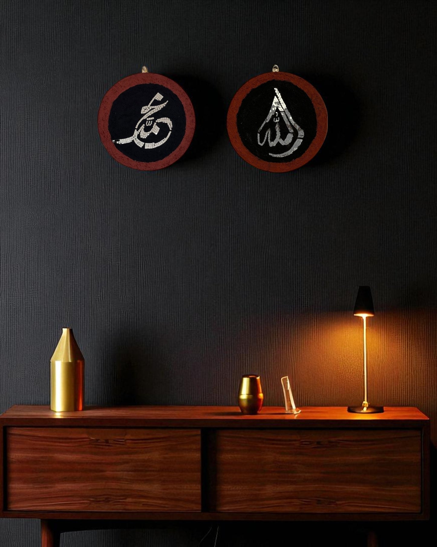 Two handcrafted Islamic calligraphy mosaic mirror pieces mounted on a dark charcoal wall above a walnut console with warm ambient lighting and golden accents