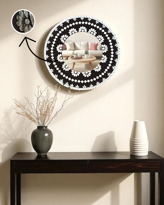 Mirroza black bloom round mirror with black floral pattern on a wall above a console table.