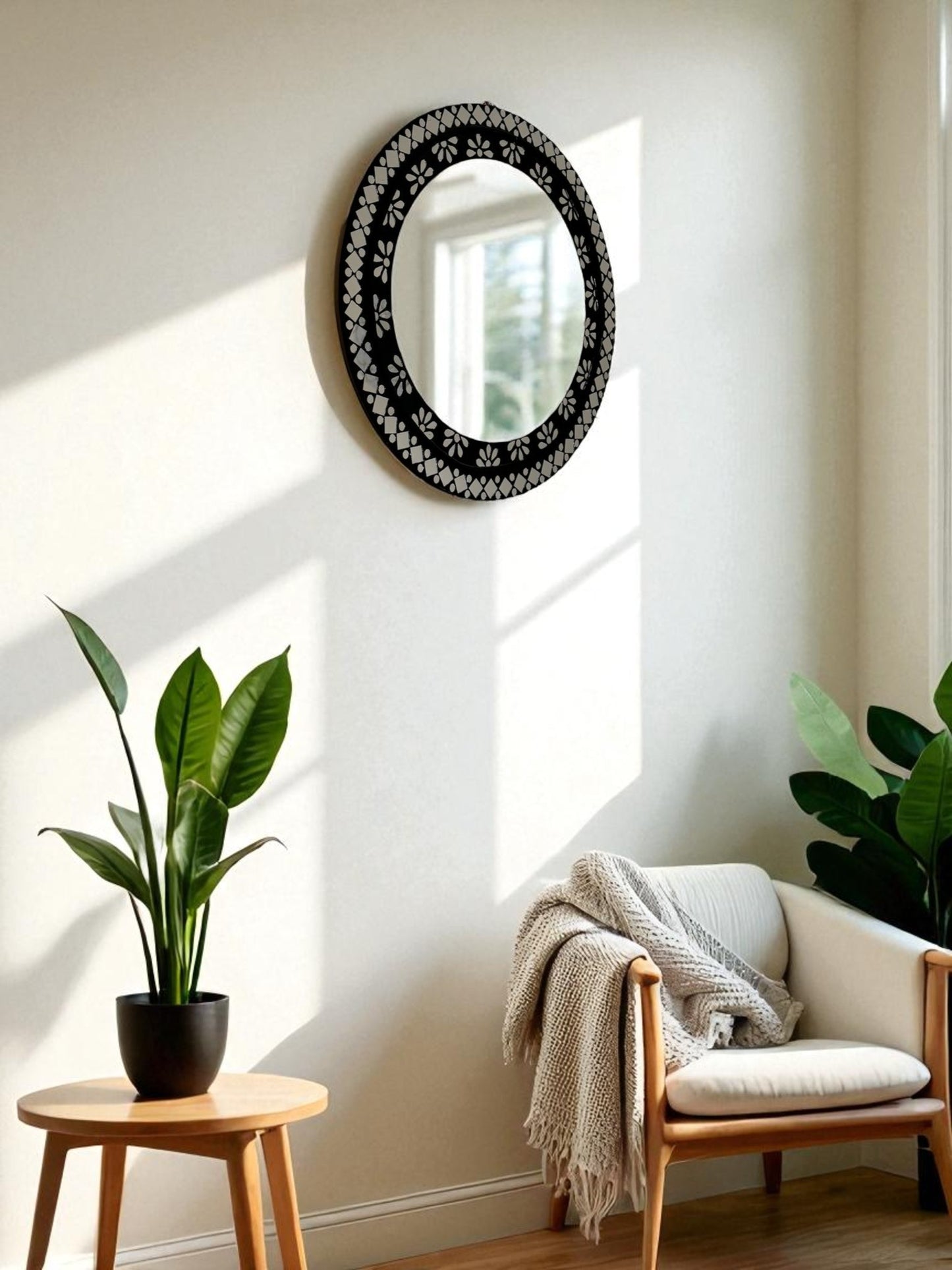 Handcrafted black mosaic mirror showcased in a boho style corner with single chair sofa and pots