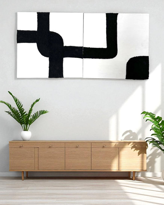 Two-panel rope abstract wall art with black and white design displayed in a minimalist Scandinavian living room with white walls and wood decor