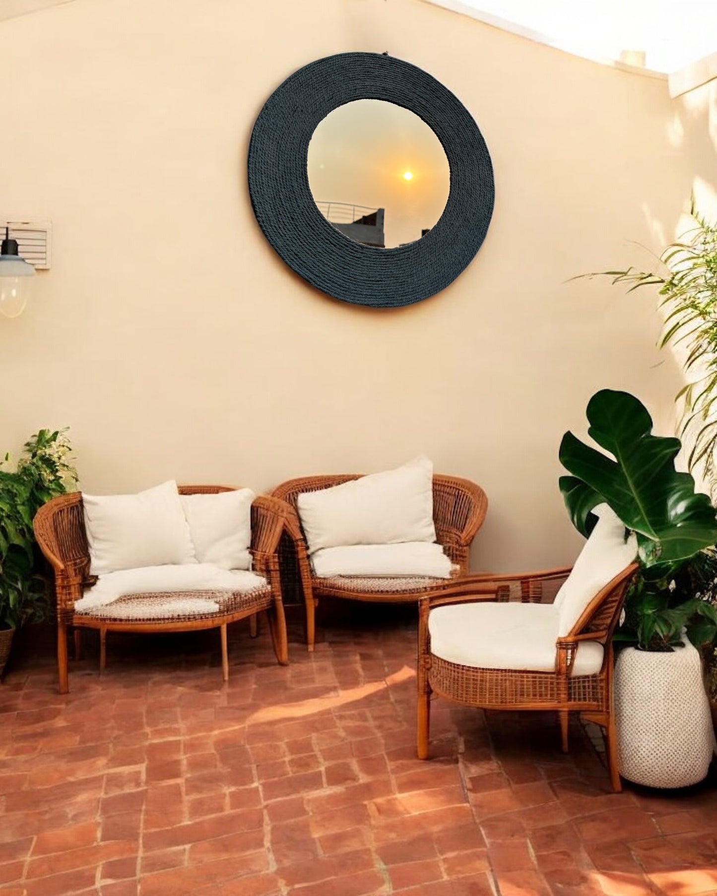 Blue Haze handcrafted rope mirror placed on patio wall with natural outdoor setting
