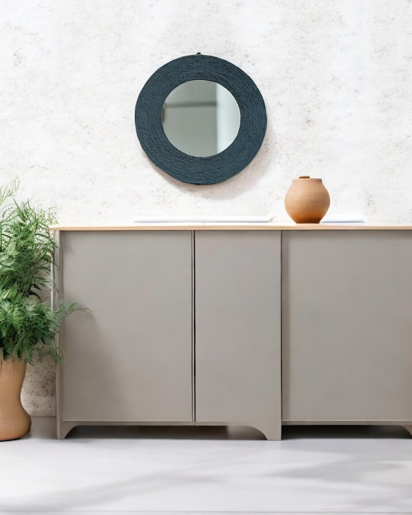 Muted blue rope mirror featured above a light-toned console table in soft daylight