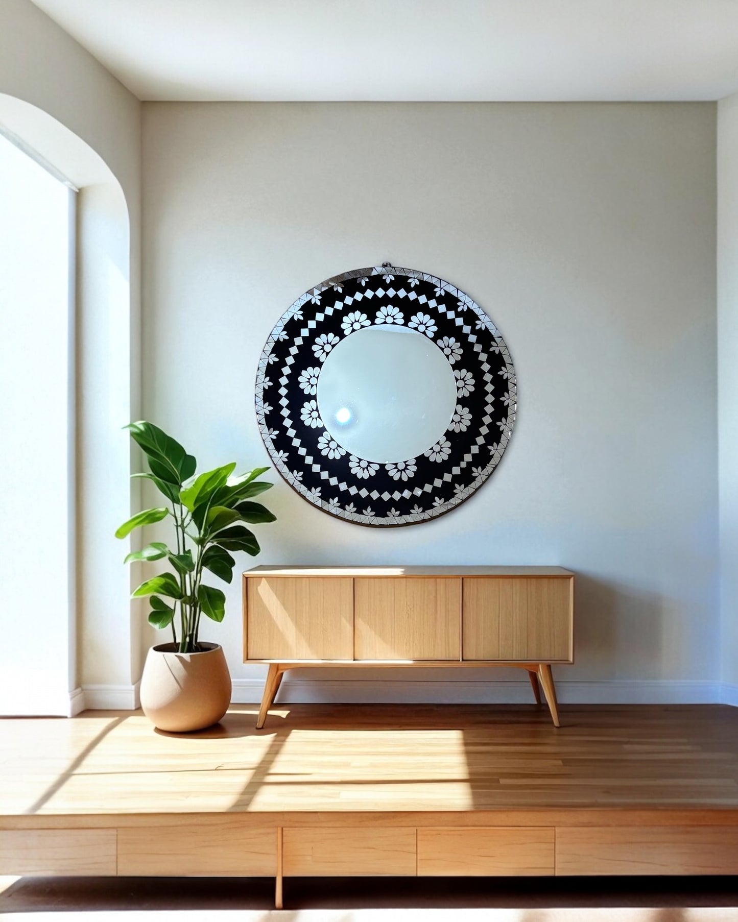 Modern interior with a Mirroza black bloom mosaic mirror, wooden cabinet, and plant.