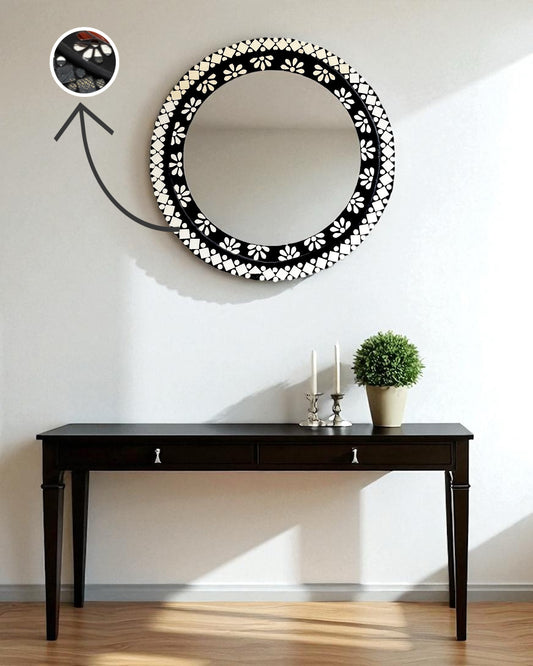 mirroza black mirror with floral patterns on a wall above a black table.