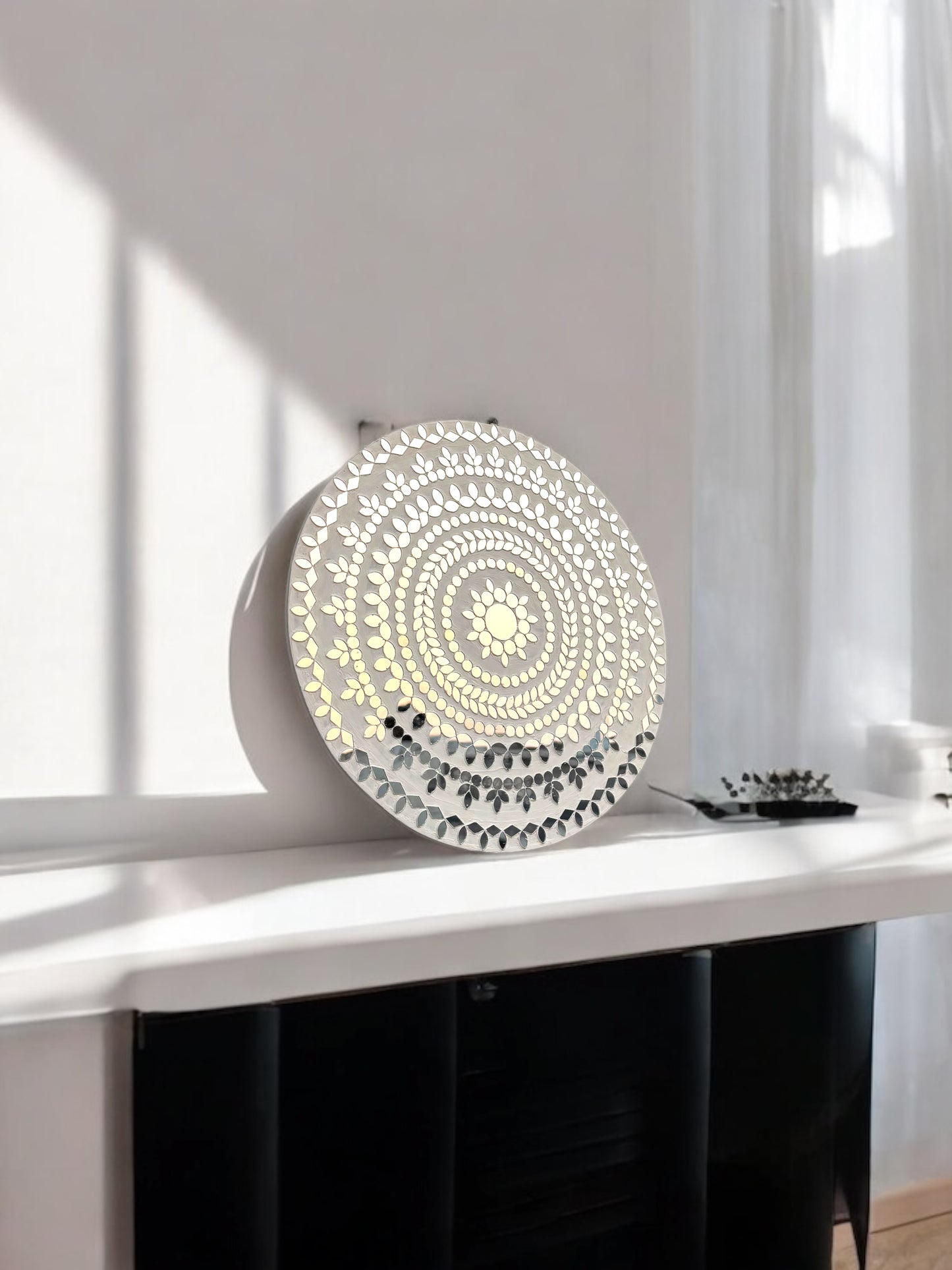 Side angle of round white handcrafted mosaic wall mirror showing reflective depth