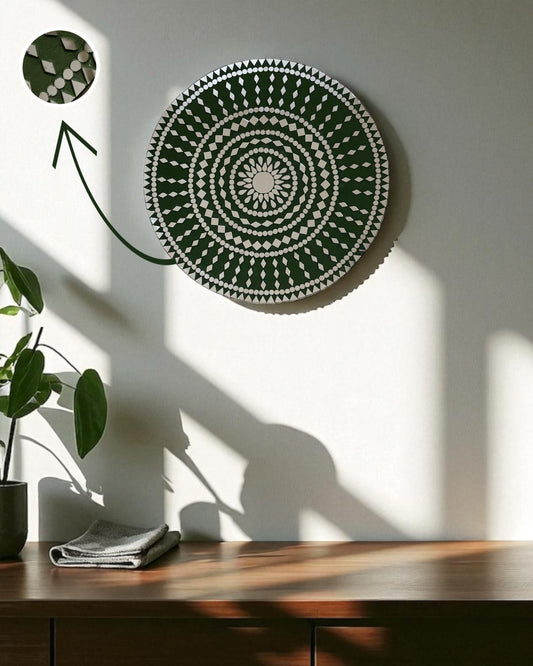 Mirroza olive bloom mirror wall art with concentric patterns on a white wall, next to a wooden table and a plant.