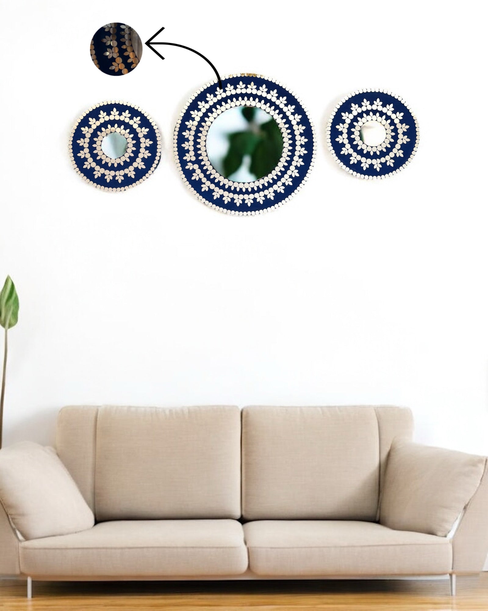Three mirror mosaic wall hangings with blue and white patterns above a beige sofa.