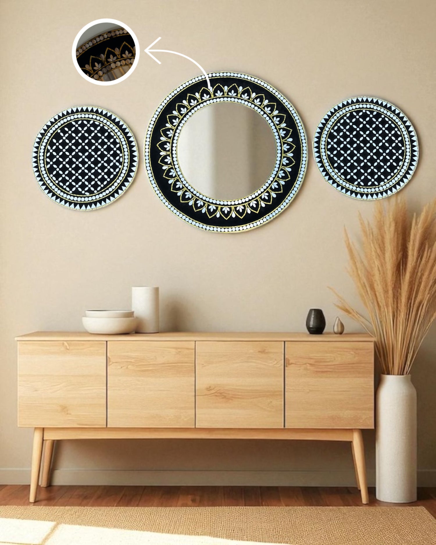Decorative mirror mosaic art set with black geometric patterns on a beige wall above a wooden console table.