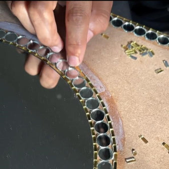 Close-up of a hand working on a mirror 