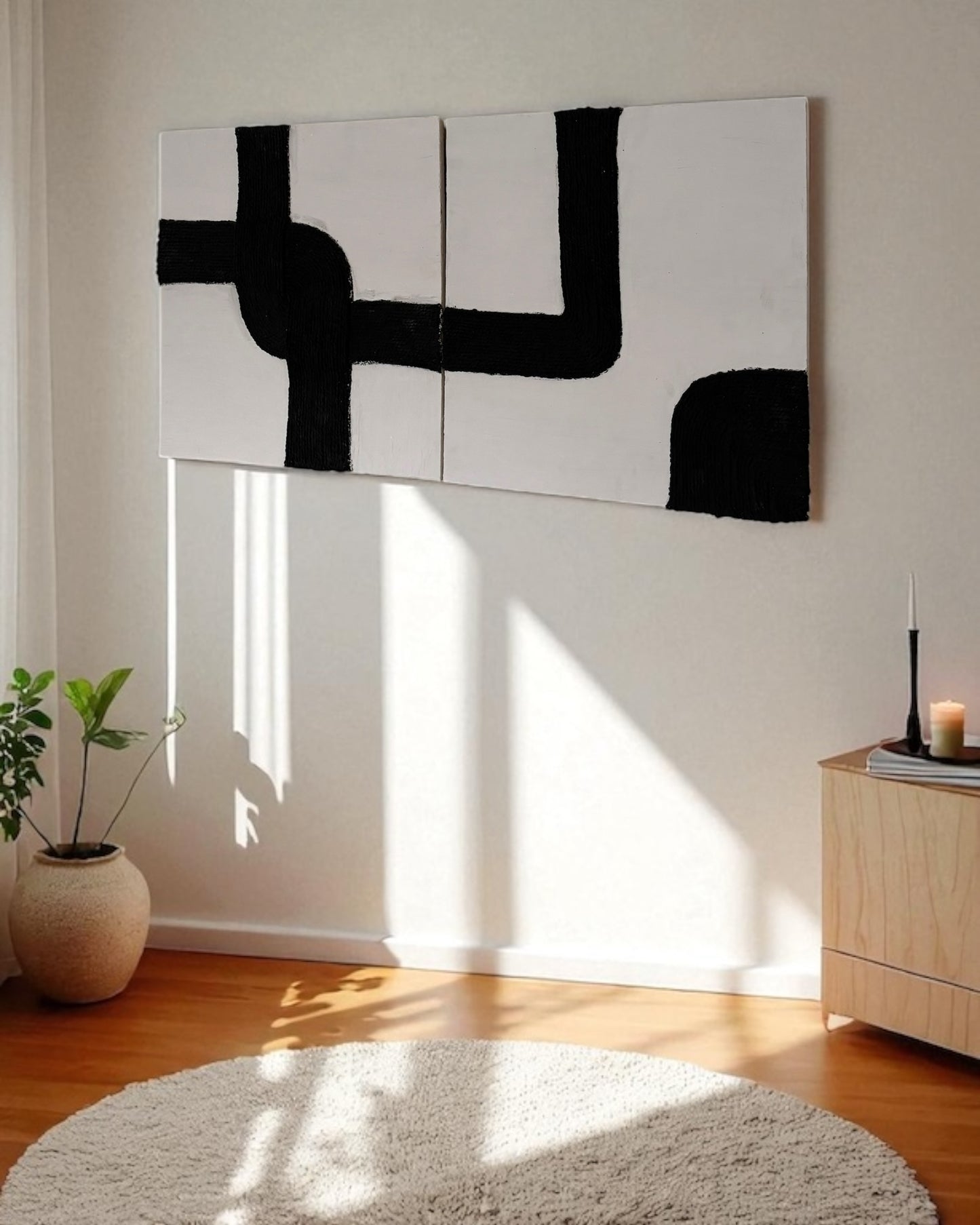 Left side view of handmade black and white rope wall art mounted on a warm plaster wall with wood accent furniture