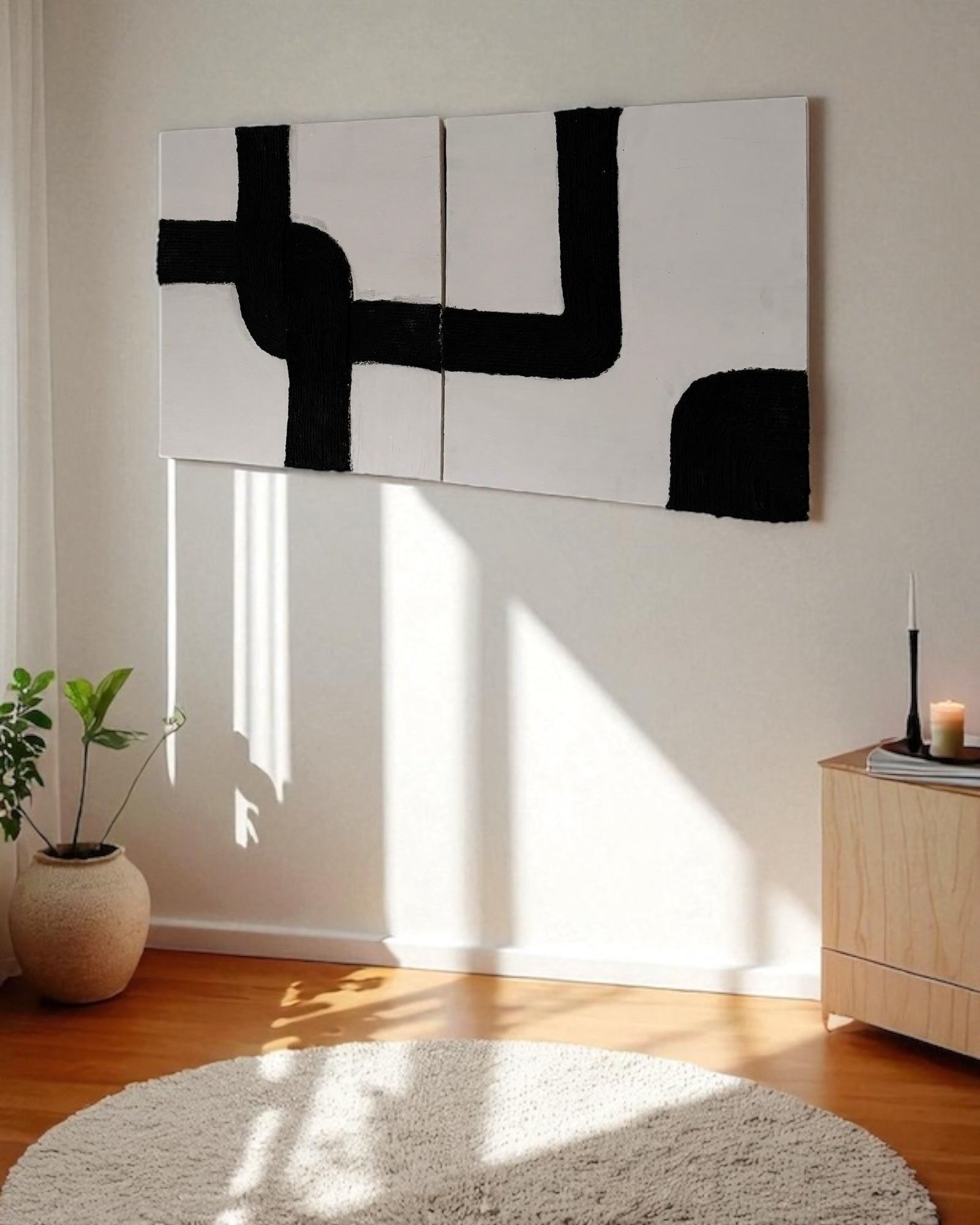 Left side view of handmade black and white rope wall art mounted on a warm plaster wall with wood accent furniture