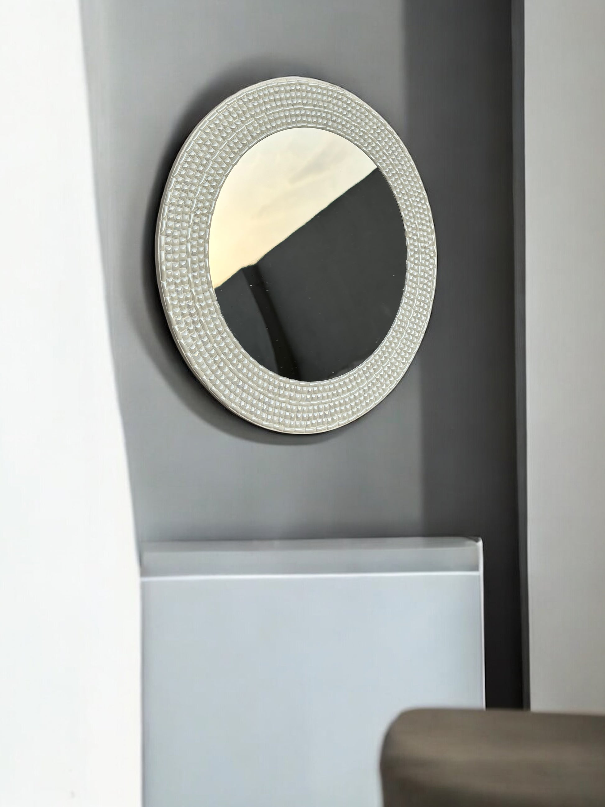 Ivory handcrafted mosaic mirror on dark wall 