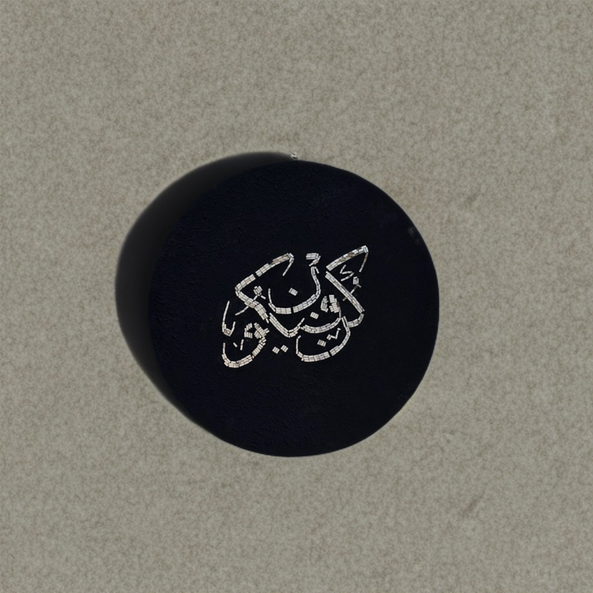 Kun Fayakun mosaic mirror calligraphy piece displayed on a concrete wall