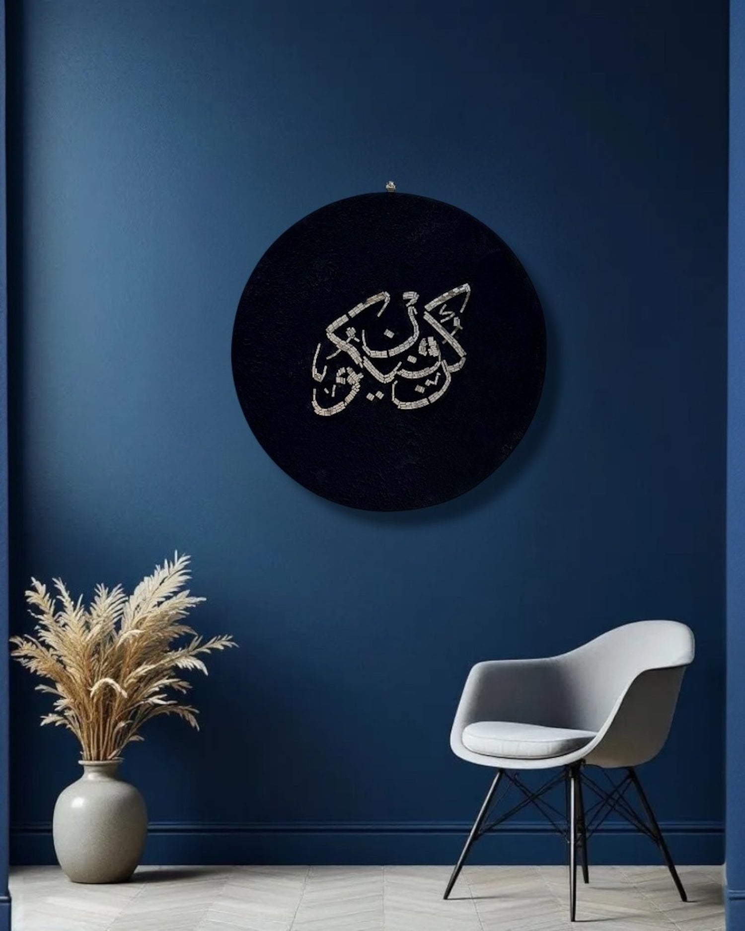 Mirroza round mirror mosaic wall art with Arabic calligraphy on a dark background, placed above a chair and plant against a blue wall.