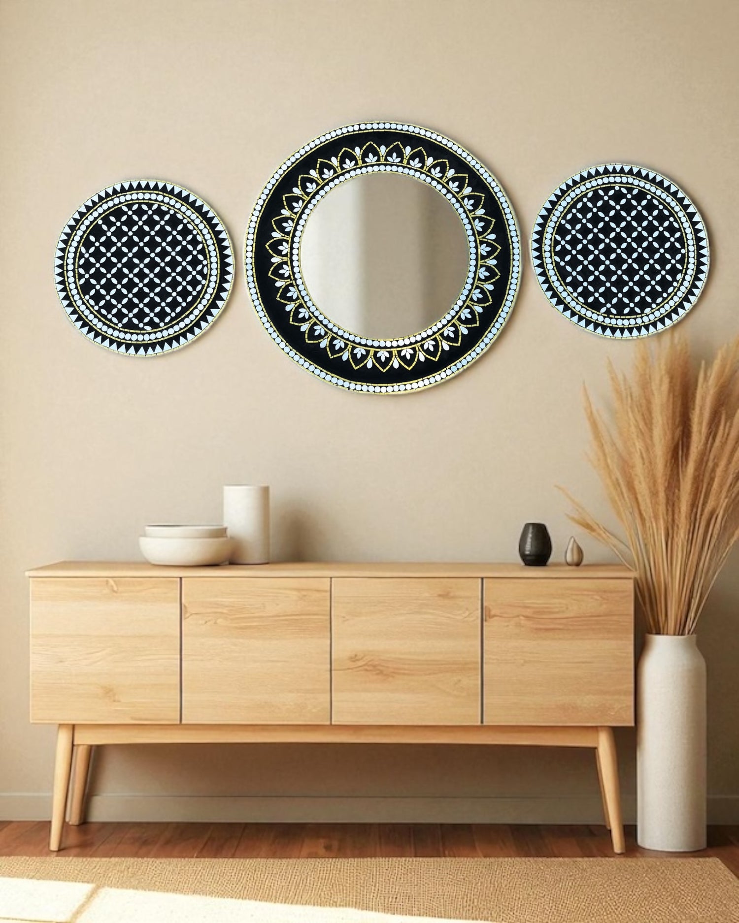 Decorative mirror mosaic art set with black geometric patterns on a beige wall above a wooden console table.