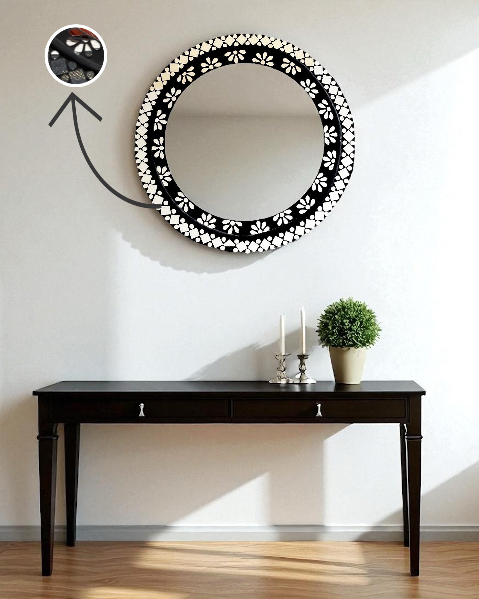 mirroza black mirror with floral patterns on a wall above a black table.