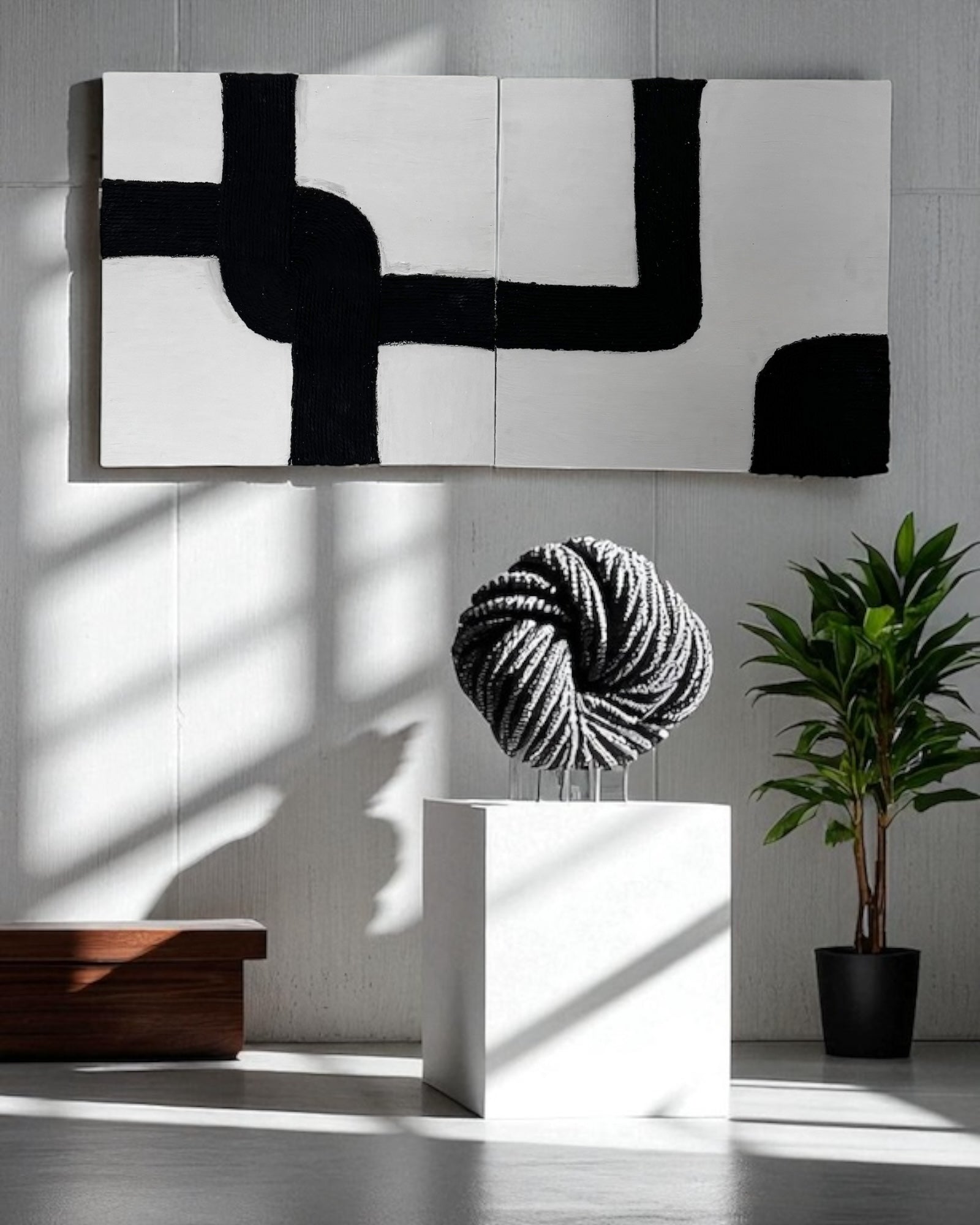 Handcrafted black and white rope abstract wall art set against an exposed concrete wall in a modern industrial loft