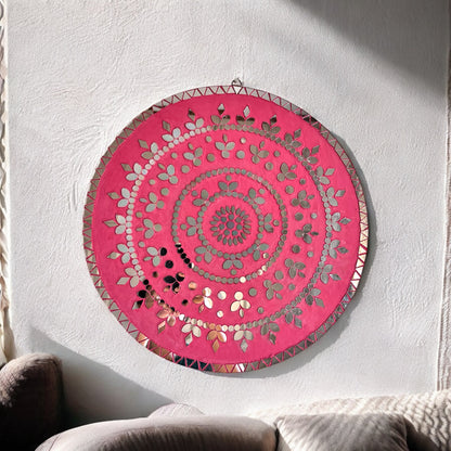 Round rose gold mosaic wall art with mirror petals and geometric border, hanging on a white textured wall.