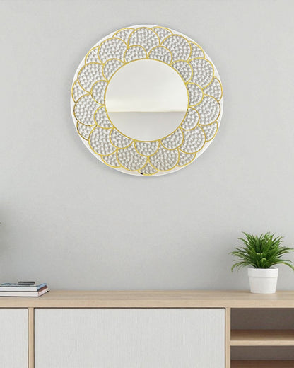 Decorative wall mirror with gold frame on a light gray wall above a wooden console table.